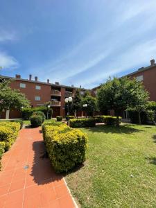 a park with bushes and a building in the background at Tristan casa vacanze a Roma in Casal Palocco