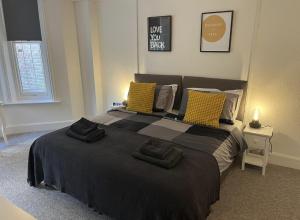 um quarto com uma cama grande e almofadas amarelas em Urban Living - Flat 2 em Bournemouth
