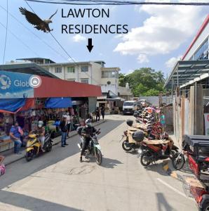 een vogel die over een straat vliegt met geparkeerde motorfietsen bij Lawton Residences Studio Room 3E in Manilla