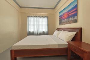 een slaapkamer met een bed, een bureau en een raam bij Lawton Residences Studio Room 3E in Manilla
