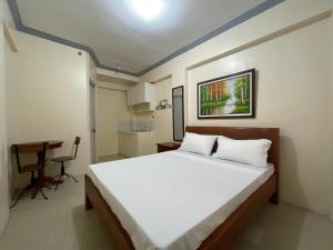 een slaapkamer met een bed en een bureau. bij Lawton Residences Studio Room 3E in Manilla
