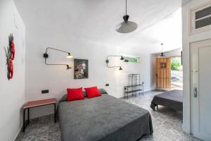- une chambre avec un lit et 2 oreillers rouges dans l'établissement La Barranca de la Barca, à Alora