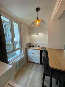 een keuken met een tafel, een wastafel en een raam bij Les 4 saisons Honfleur - Studio 2 in Honfleur