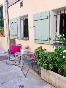 stół i 2 krzesła obok budynku w obiekcie Artistic Antibes Apartment w mieście Antibes