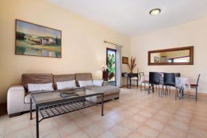 una sala de estar con un sofá y una mesa en La Palmera de la Oliva, en La Oliva