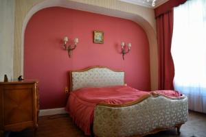 a bedroom with a red wall with a bed at Chez anne in Charleville-Mézières