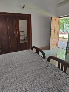 ein Esszimmer mit einem Tisch, Stühlen und einer Tür in der Unterkunft Akkara Homestay & Ayurveda in Kottayam