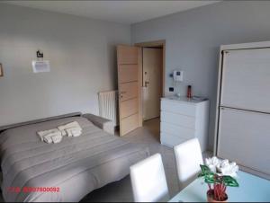 a bedroom with a bed and a dresser and a refrigerator at Domus Parca Apartment, Host: Shamira in Cuneo