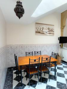 a dining room with a wooden table and chairs at Les Riads Nour Resorts- Marrakesh Escape in Marrakech