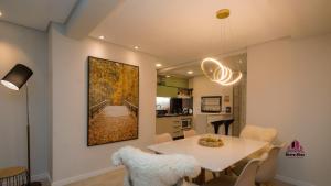 a dining room and kitchen with a white table and chairs at Apto Luxo Vila di Tondo Area Lazer na Cobertura in Bento Gonçalves