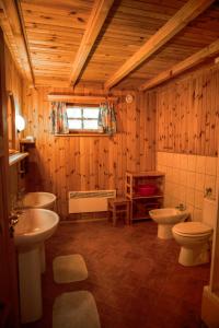 a bathroom with two toilets and a sink and a tub at Domki nad stawami - Pommernhof in Ustronie Morskie +70 photos
