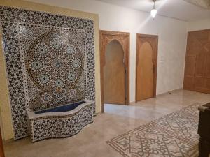 una habitación con una pared con una pared estampada en Dar HAKIM piscine privée en Marrakech