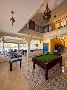una gran sala de estar con una mesa de billar. en Dar HAKIM piscine privée en Marrakech