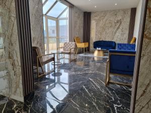 a lobby with chairs and tables and a window at Hôtel Restaurant Le Relais - Pau Nord in Lons