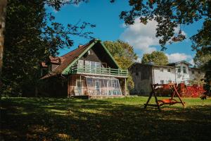 an old house with a playground in the yard at Domki nad stawami - Pommernhof in Ustronie Morskie