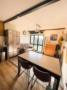 een woonkamer met een tafel en 2 stoelen bij Appartement cosy - Le Chat Gris in Métabief