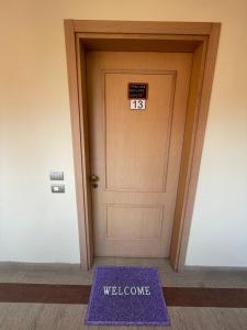 a welcome mat in front of a door with a welcome sign at Tristan casa vacanze a Roma in Casal Palocco