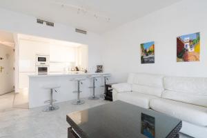 een witte woonkamer met een witte bank en een keuken bij Reserva de Marbella in Marbella
