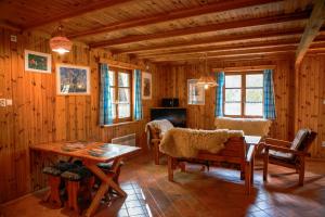 a living room with a table and chairs in a cabin at Domki nad stawami - Pommernhof in Ustronie Morskie