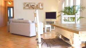 uma sala de estar com uma mesa e um sofá em Appartement 5 personnes - Mas du Soleil em Bagnols-sur-Cèze