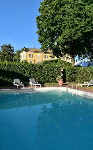 a large swimming pool with two chairs and a building at Country Loft at Palazzo di Bagnaia in Castel del Piano