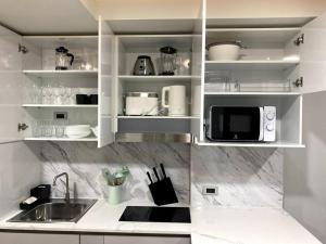 a white kitchen with a sink and a microwave at New apartment Rawai Beach 310 by Capital Pro in Phuket