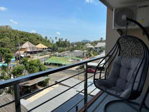 a chair on a balcony with a view of a street at New apartment Rawai Beach 310 by Capital Pro in Phuket