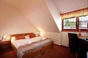 sypialnia z łóżkiem, biurkiem i oknem w obiekcie Golf&Wellness Resort Alfrédov w mieście Alfrédov +37 zdjęć