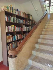 a staircase with a book shelf filled with books at Akkara Homestay & Ayurveda in Kottayam