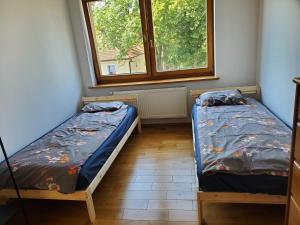 two twin beds in a room with a window at Apartament w Gdańsku Brzeźnie in Gdańsk