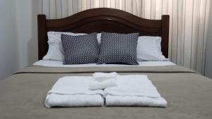 - un lit avec 2 serviettes assises au-dessus dans l'établissement Loft Aconchegante Centro Niterói / RJ Inter 300Mb, à Niterói
