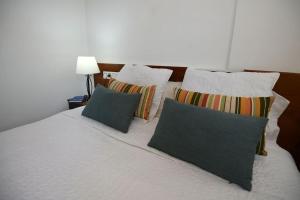 a bedroom with a bed with pillows and a lamp at VUT dos dormitorios in Pontevedra
