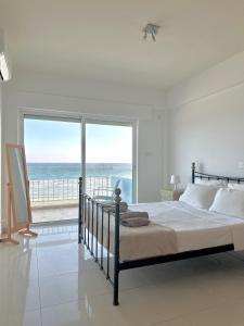 a bedroom with a bed with a view of the ocean at Sayers Beachfront Villa in Perivolia