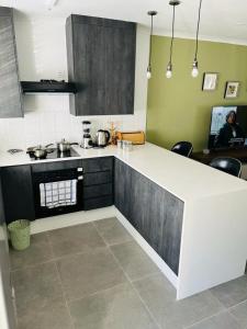 a kitchen with a white counter top in a room at Comfy Zone Apartment in Gaborone
