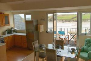 uma cozinha com uma mesa e uma cozinha com vista para o oceano em Beach Side Top Floor Property, Balcony & Sea Views em Newquay