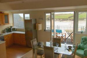 a kitchen with a table and a kitchen with a view of the ocean at Beach Side Top Floor Property, Balcony & Sea Views in Newquay +18 photos