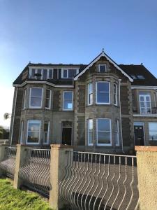 a brick house with a fence in front of it at Beach Side Top Floor Property, Balcony & Sea Views in Newquay