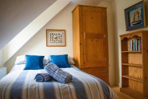 una camera con letto con lenzuola blu e armadio in legno di Beach Side Top Floor Property, Balcony & Sea Views a Newquay