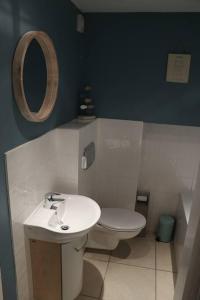 a bathroom with a sink and a toilet and a mirror at Beach Side Top Floor Property, Balcony & Sea Views in Newquay