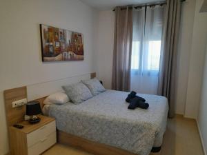 a teddy bear sitting on a bed in a bedroom at Apartamento Isabel in Sant Carles de la Ràpita