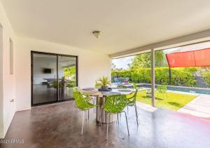 a dining room with a table and green chairs at Designer 5 Bd Home, Fountain Pool, Spa, Game Patio in Phoenix