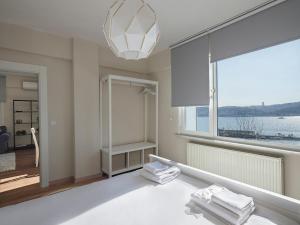 Gorgeous 3bed2bath Bright Bosphorus Views! #55 في إسطنبول: غرفة بيضاء مع نافذة كبيرة وثريا