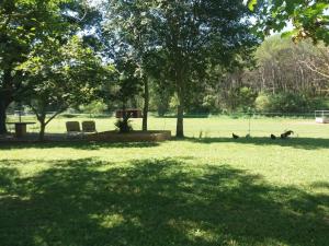 een park met twee stoelen en bomen in het gras bij Gite des Suis in Villecroze