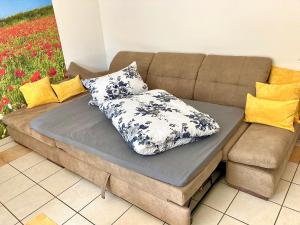 a couch with two pillows on top of it at Ferienwohnung Gerne-Da in Großrinderfeld