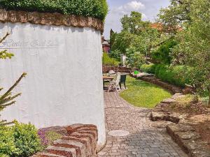 a stone wall with a table and chairs in a garden at Ferienwohnung Gerne-Da in Großrinderfeld