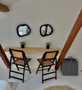 two chairs and a table in a room with two mirrors at Same Home in Cassis