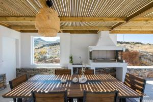 a dining room with a wooden table and chairs at KEA 360 VILLAS-Hermes Hideout in Pisses