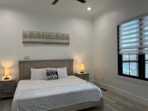 a bedroom with a bed and a window with two lamps at Amazing New House - Waterfront Getaway + Boat Dock in Dandridge +88 photos