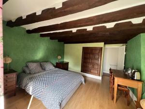 um quarto com paredes verdes, uma cama e uma secretária em Chambres d'hôtes "Là Je Ris" em Lagery