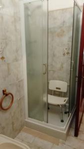 a shower with a white chair in a bathroom at Casa a Sorso per le tue vacanza in Sorso